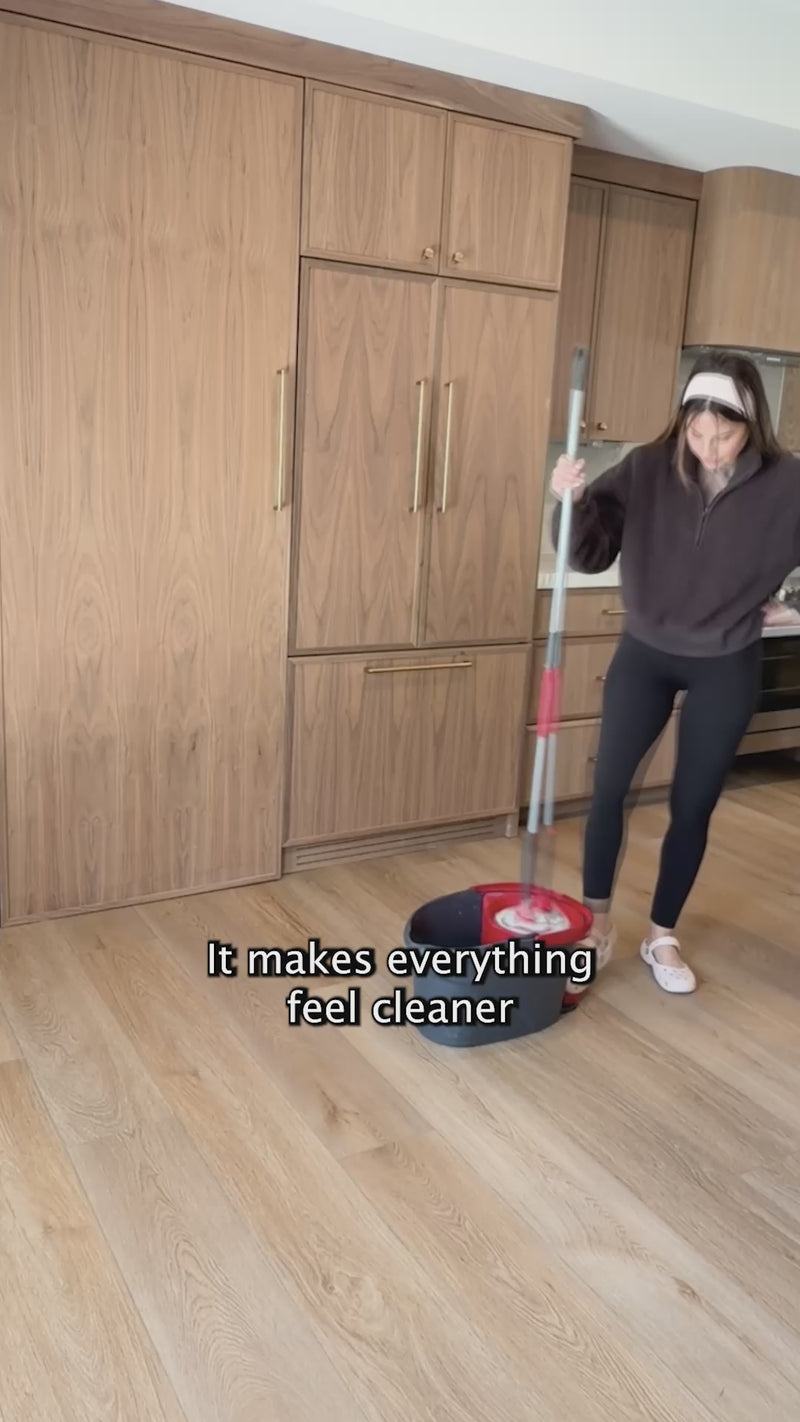 A woman mopping her kitchen in a video featured on the Blyss website