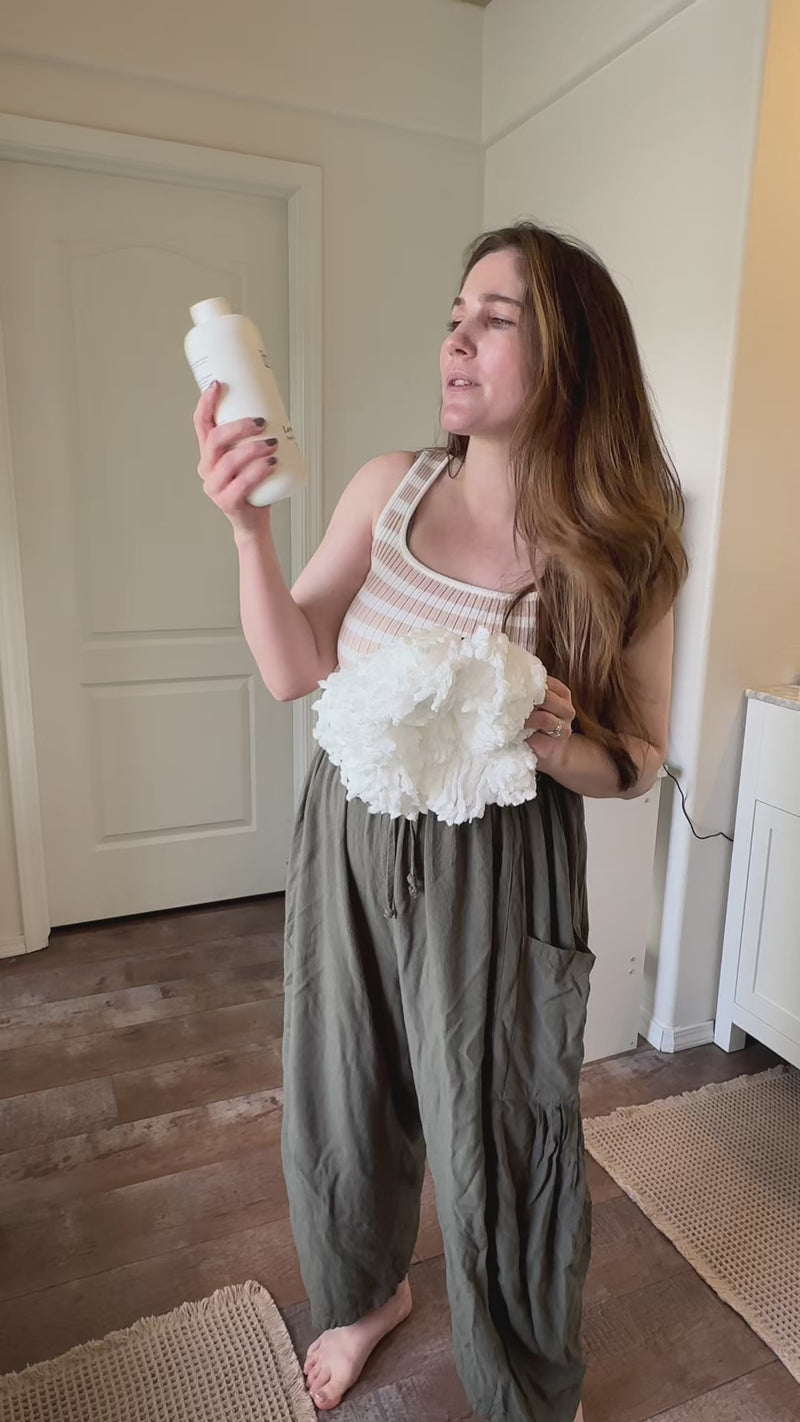 Woman holding a Blyss bottle and a mop head
